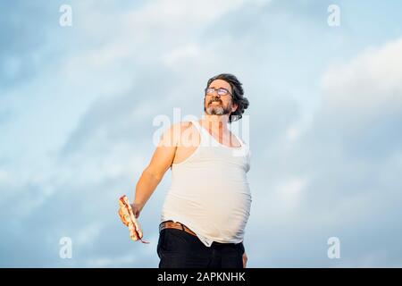 Mann mit Bierbauch, der Sandwich hält Stockfoto