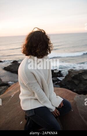 Eine gemütliche Frau blickt auf die atemberaubende Aussicht von Punta Lobos in Chile. Stockfoto