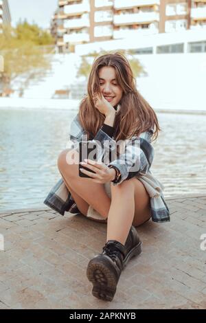 Junge Brunette-Frau mit Smartphone und einer selfie Stockfoto