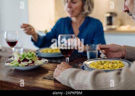 Reifes Paar, das zu Hause in der Küche zu Abend essen kann Stockfoto