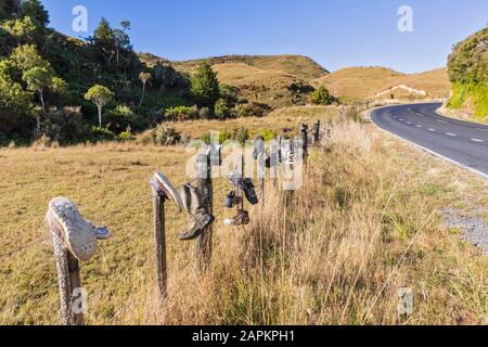 Neuseeland, Ozeanien, Nordinsel, Waitomo, Schuhe auf Holzpfosten entlang der Te Anga Road Stockfoto