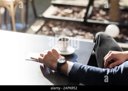 Mann trinkt Kaffee im Café im Freien Stockfoto