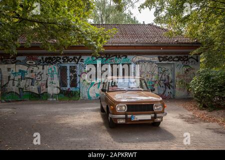 Deutschland, Berlin, Brauner Oldtimer parkte vor dem Gebäude mit Graffiti bedeckt Stockfoto