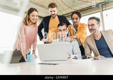 Geschäftsleute, die ein Meeting mit einem Laptop im Büro haben Stockfoto