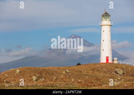 Neuseeland, South Taranaki District, Pungarehu, Cape Egmont Leuchtturm mit Mount Taranaki Vulkan im Hintergrund Stockfoto