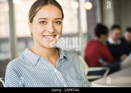 Porträt einer lächelnden jungen Geschäftsfrau während eines Treffens im Büro Stockfoto