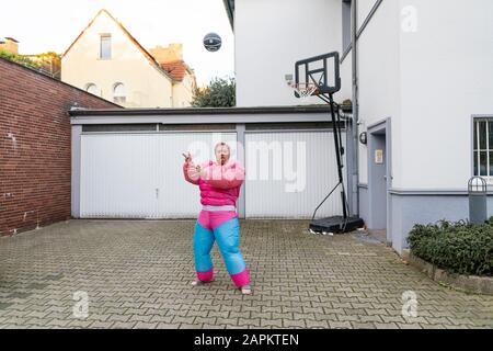 Porträt eines Mannes mit Basketball mit pinkfarbenem Bodybuilder-Kostüm Stockfoto