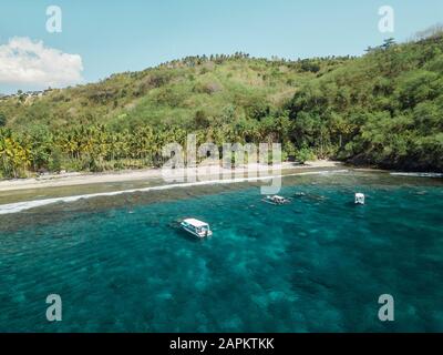 Indonesien, Bali, Boote, die im Wasser vor der Küste der Insel Nusa Penida schwimmen Stockfoto