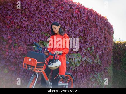 Junge Frau aktiviert Leihfahrrad mit Smartphone-App Stockfoto