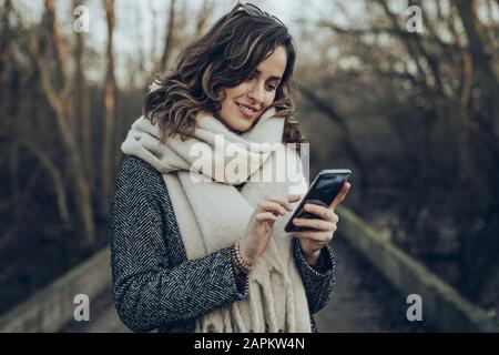 Portrait junger brünette Frau mit Smartphone Stockfoto