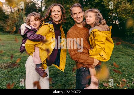 Porträt einer glücklichen Familie mit zwei Töchtern im Herbst im Freien Stockfoto