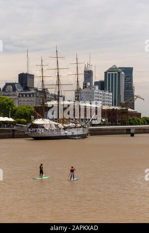 Blick auf ein paar Männer auf Stand Up Paddle Boards auf dem Fluss in Puerto Madero, Buenos Aires, Argentinien Stockfoto