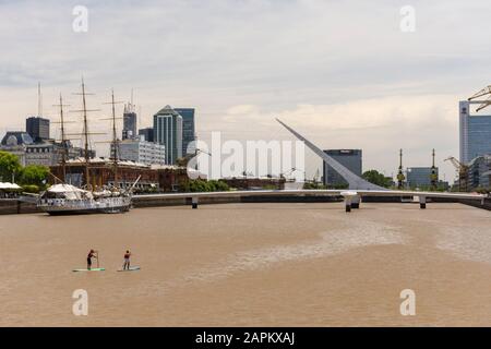 Blick auf ein paar Männer auf Stand Up Paddle Boards auf dem Fluss in Puerto Madero, Buenos Aires, Argentinien Stockfoto