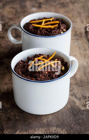 Tassen Gluten- und laktosefreie Schokoladenpuddings mit Canihua, Chili und Orange Stockfoto
