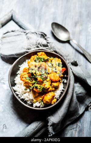 Schale veganes Curry mit Kartoffeln, Karotten, Erbsen, Petersilie und Kürbis Stockfoto