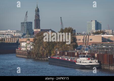 Deutschland, Hamburg, Containerschiff im Hafen mit Turm der St. Michaels Kirche im Hintergrund Stockfoto