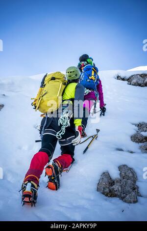 Alpinisten, die einen verschneiten Berg aufsteigen, Orobie Alps, Lecco, Italien Stockfoto