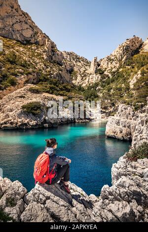 Frankreich, Cote d'Azur, Nationalpark Calanques, Frau mit Rucksack, Blick auf Kreidefelsen und Buchten Stockfoto