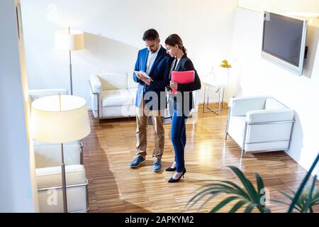 Geschäftsmann zeigt Kollegen in der Lounge Tablet Stockfoto