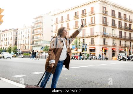 Junge Frau in der Stadt, die ein Taxi fährt, Barcelona, Spanien Stockfoto