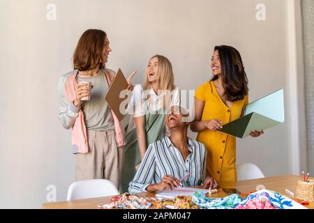 Fröhliche Modedesigner, die ein Treffen im Büro haben Stockfoto