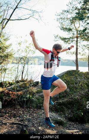 Mann, der am Seeufer über ein Hindernis springt, Forstsee, Carinth, Österreich Stockfoto