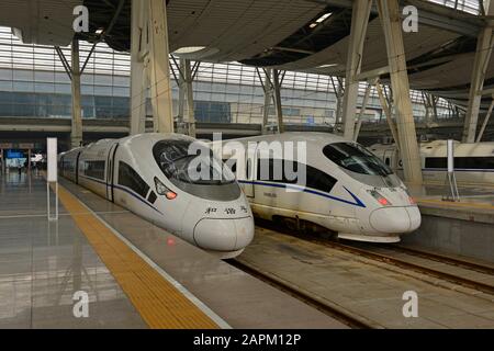 Zwei Hochgeschwindigkeitszüge der CRH warten auf die Abfahrt nach Qingdao am Pekinger Südbahnhof, Peking, China Stockfoto