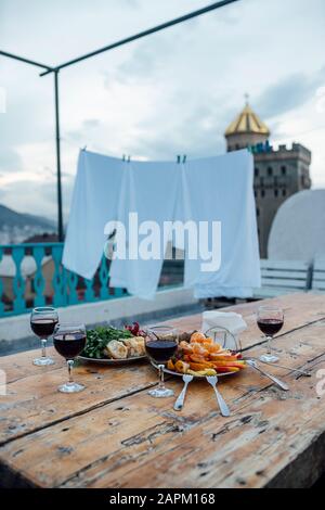 Georgien, Tiflis, frisches Obst und Gläser Rotwein auf Holztisch im Freien Stockfoto