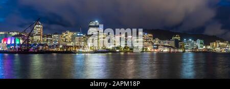 Neuseeland, Wellington, Panorama der beleuchteten Skyline der Stadt am Wasser bei Nacht Stockfoto