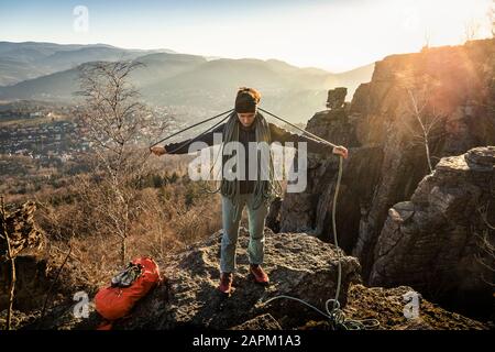 Weiblicher Kletterer mit Seil auf Battert-Rock bei Sonnenuntergang, Baden-Baden, Deutschland Stockfoto