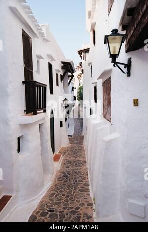 Spanien, Menorca, Binibeca, weiß getünchte Häuser und enge Gasse Stockfoto