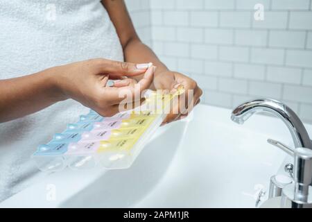 Nahaufnahme der Frau, die im Bad Pille genommen hat Stockfoto