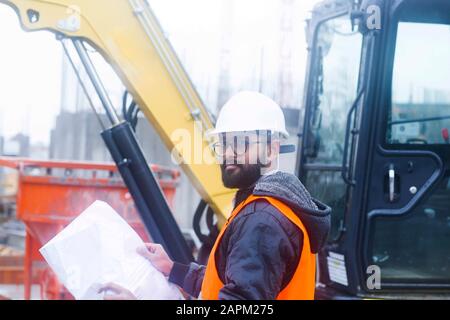 Bauingenieur an der Baustelle mit Hut und Sicherheitsweste Stockfoto