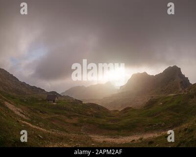 Italien, Trentino, Pasubio-Massiv, Vicentine Alpen, Strada degli Eroi und Strada degli Scarubbi, Sturmwolken über dem Tal und kleine Hütte Stockfoto