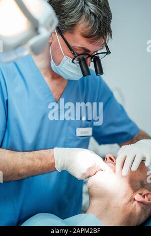 Der Zahnarzt wotking auf den Zähnen des Patienten in der Zahnchirurgie Stockfoto