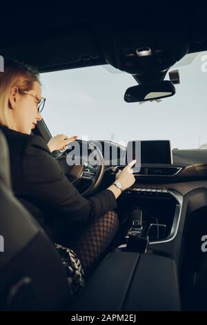 Junge Frau mit Navigationsgerät im Auto Stockfoto