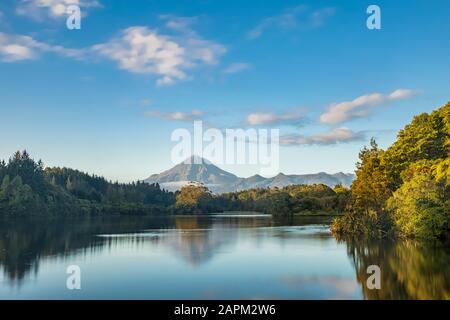 Neuseeland, lange Exposition des Lake Mangamahoe mit dem Mount Taranaki im Hintergrund Stockfoto