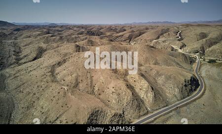 Luftbild einer schmutzigen Strecke, die die Wüste, das Wüstengebiet der Namib, in Namibia durchquert Stockfoto