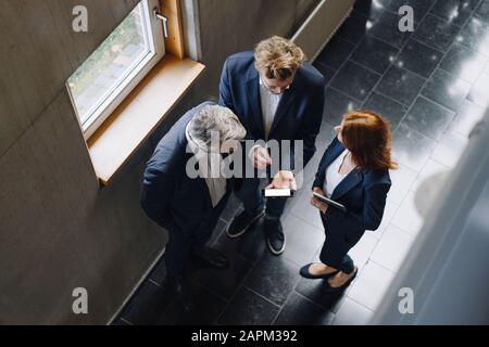 Geschäftsleute mit Smartphone im modernen Bürogebäude Stockfoto