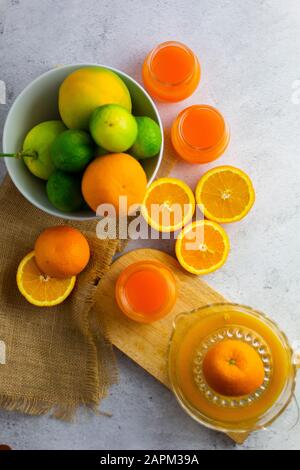 Entsafter, reife Zitrusfrüchte und Gläser frisch gepressten Orangensaft Stockfoto
