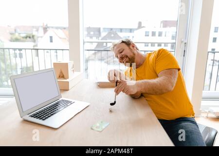 Geschäftsmann, der auf dem Schreibtisch im Büro Golf spielt Stockfoto