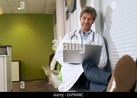 Arzt, der Laptop in seiner medizinischen Praxis verwendet Stockfoto