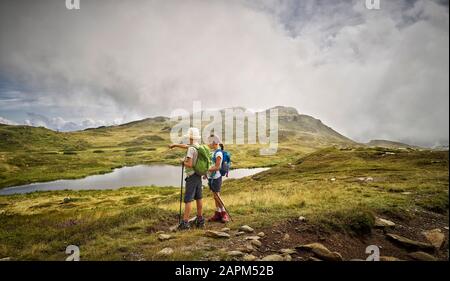 Junge und Mädchen stehen an einem See in alpiner Landschaft, Passeiertal, Südtirol, Italien Stockfoto