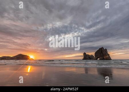 Neuseeland, South Island, Tasman, Wharariki Beach und Archway Islands bei Sonnenuntergang Stockfoto