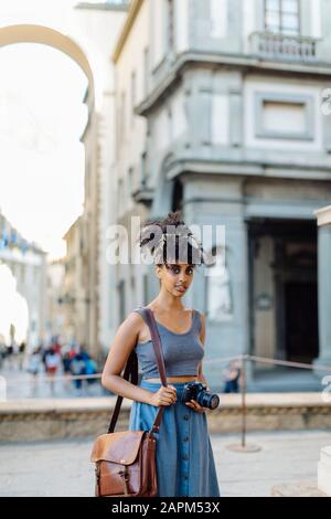 Porträt der jungen Frau mit Kamera, die die Stadt, Florenz, Italien, erkunden kann Stockfoto