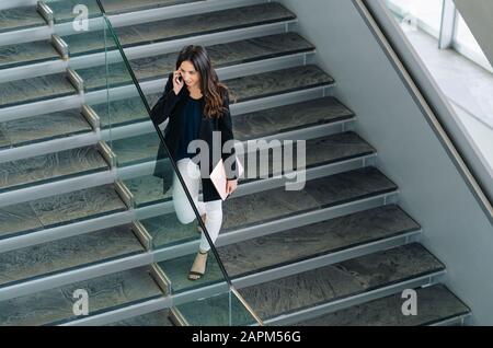 Geschäftsfrau auf der Treppe, die am Telefon spricht Stockfoto