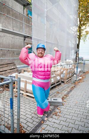 Porträt eines stolzen Mannes mit pinkfarbenem Bodybuilder-Kostüm und Hut auf der Baustelle Stockfoto