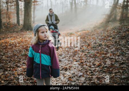 Mutter mit Töchtern beim Waldwwalk im Herbst Stockfoto