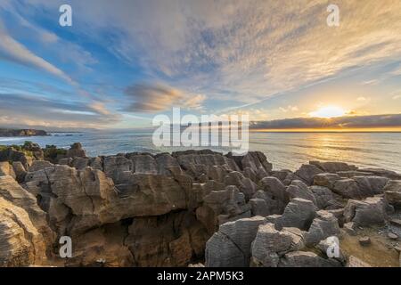 Neuseeland, Buller District, Punakaiki, Kalkstein Pancake Rocks Formation und Küstenloch bei Sonnenuntergang Stockfoto