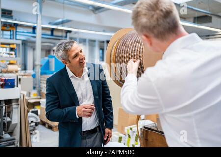 Zwei Geschäftsleute sprechen in einer Fabrik Stockfoto